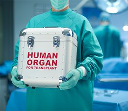En sjuksköterska som håller i en organlåda. 